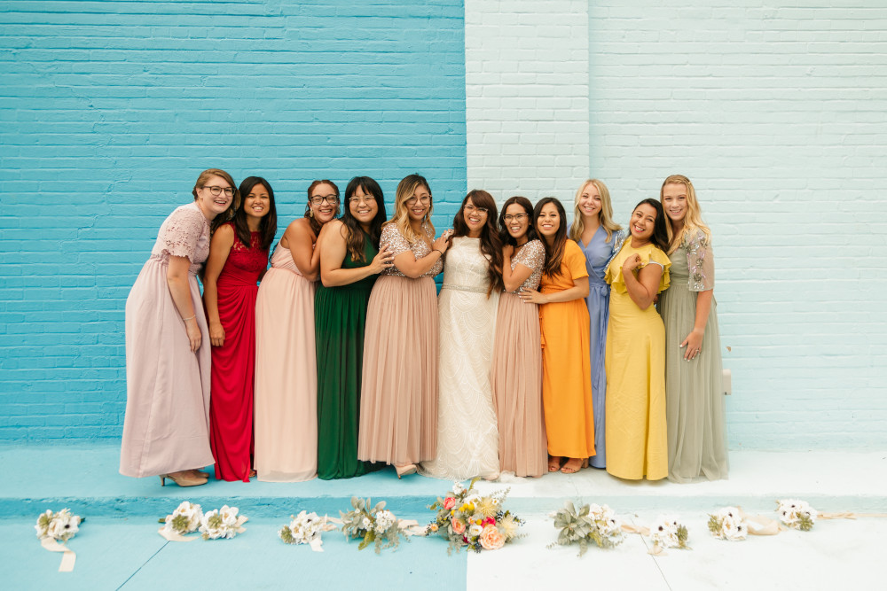 Bride and bridesmaids in colorful dresses next to Color Wall at Haus 820 in Lakeland, FL